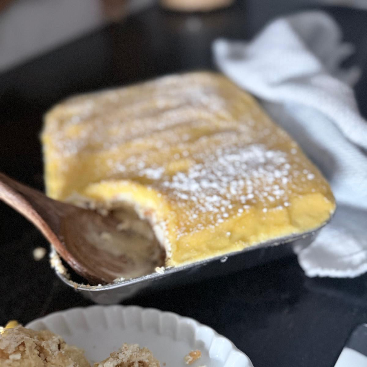 Square pastry with a wooden spoon and a piece on a plate